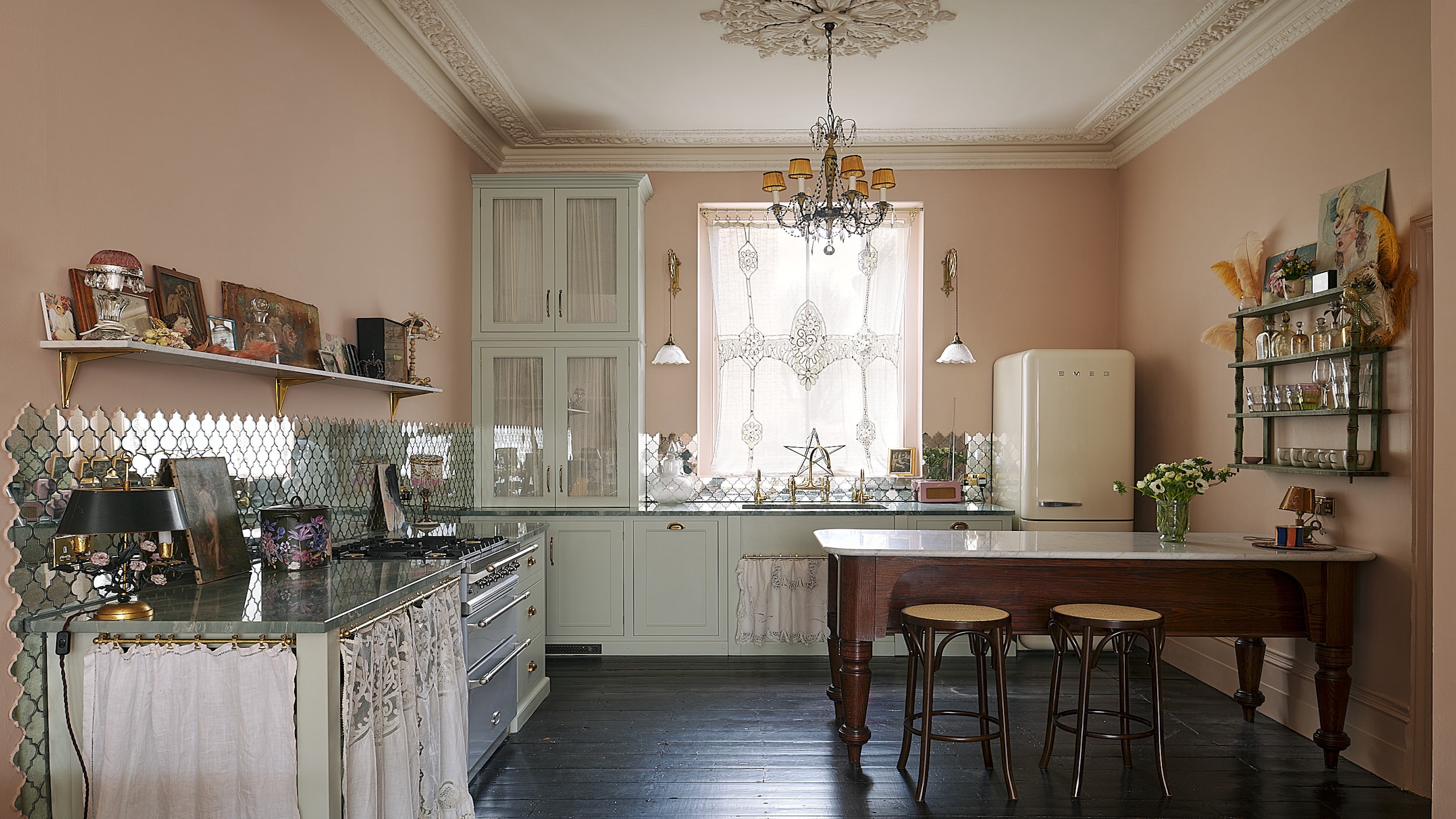 A kitchen with pastel tones used throughout. There is also a mini kitchen island/ dining area in the kitchen. 