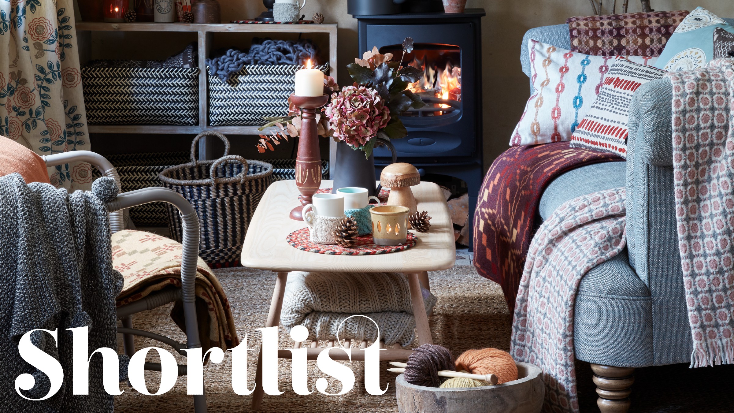 A cosy living room with a light blue sofa and lots of wool and knitted throws