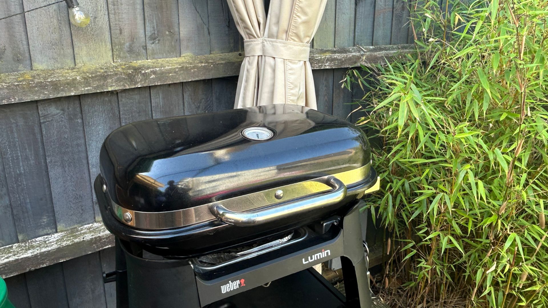 Black weber BBQ in garden under pergola