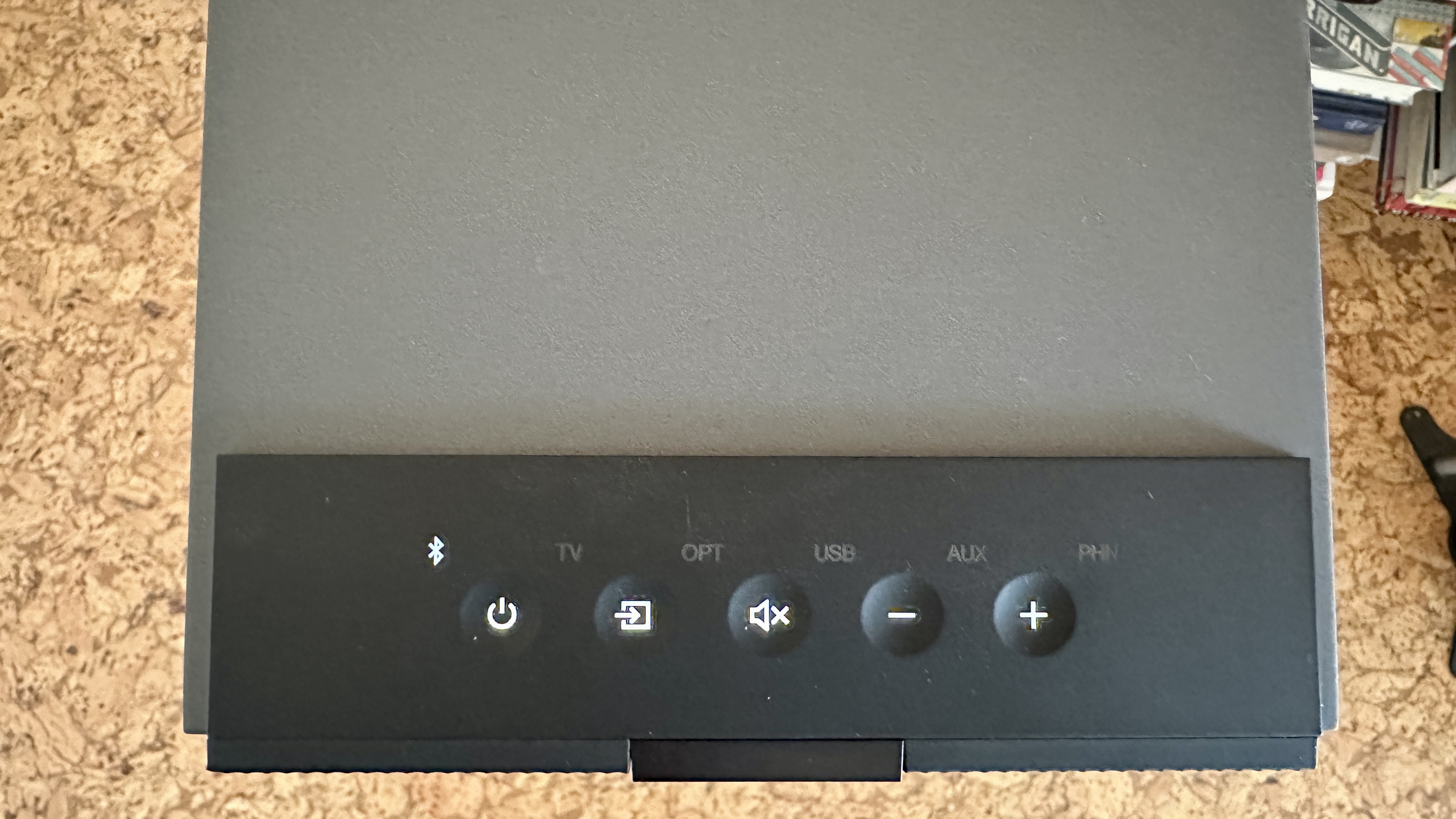 Top panel of the KEF Coda W active speaker system, with back-lit, recessed touch-control buttons for power on/off, volume control and Bluetooth connectivity.