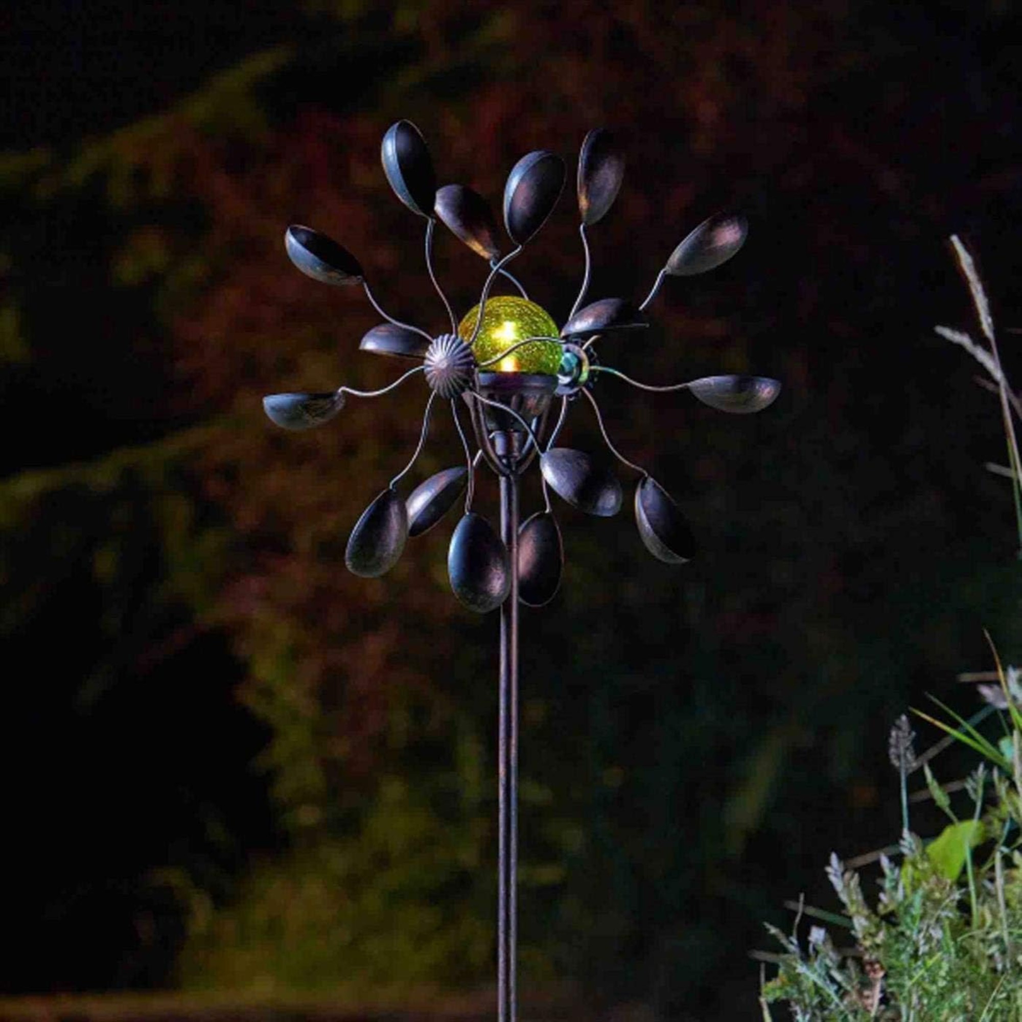 The Gemini Wind Spinner with Solar Crackle Globe glowing at night