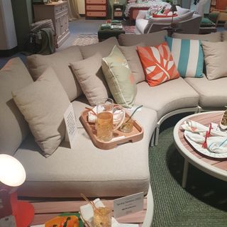 An outdoor furniture set-up from the John Lewis spring/summer 2025 press showcase with a curved outdoor sofa