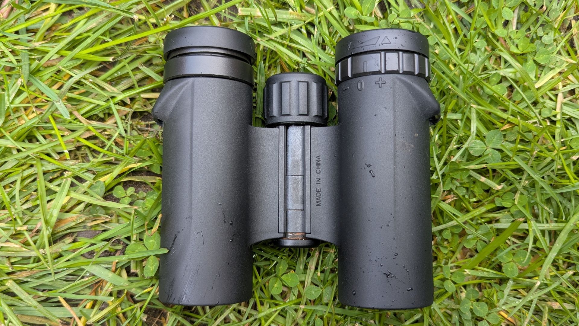 Celestron Outland X 10x25 lying on the grass during the hands-on review