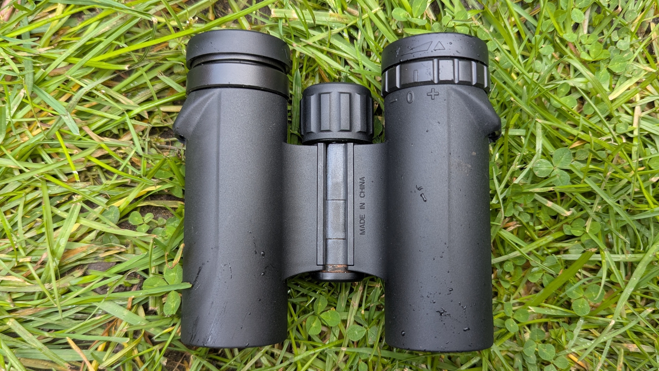 Celestron Outland X 10x25 lying on the grass during the hands-on review