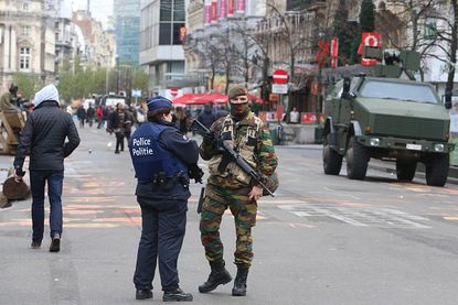 A solider and police officer patrol a boulevard in Brussels