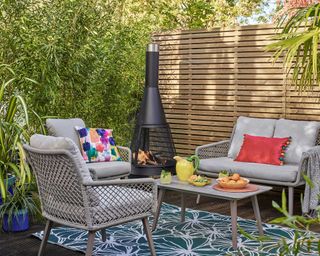 outdoor living space with chiminea and patterned rug from Dobbies