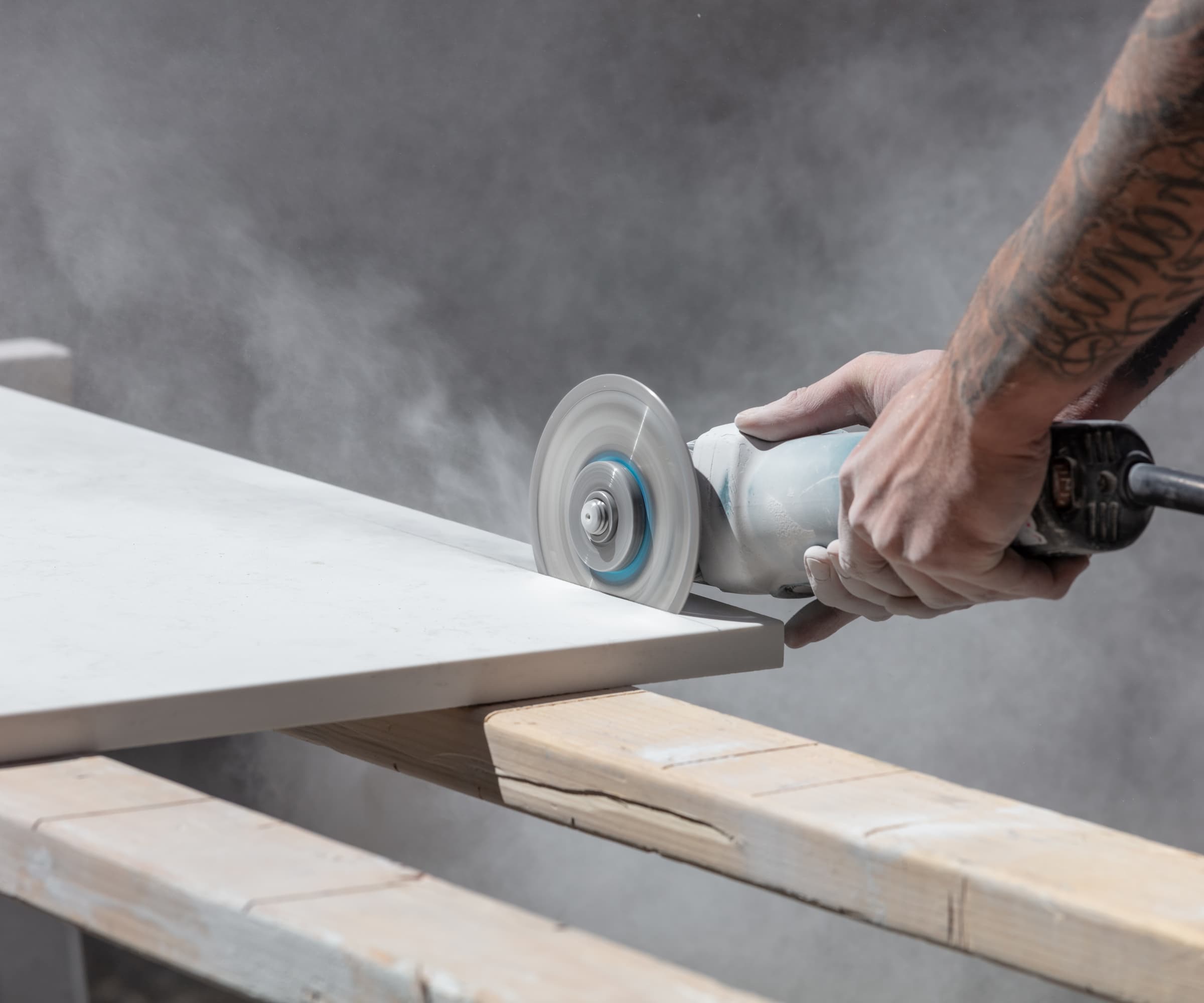 Man cutting kitchen countertop with saw with tattoos