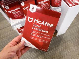 Hand holding a McAfee Total Protection package