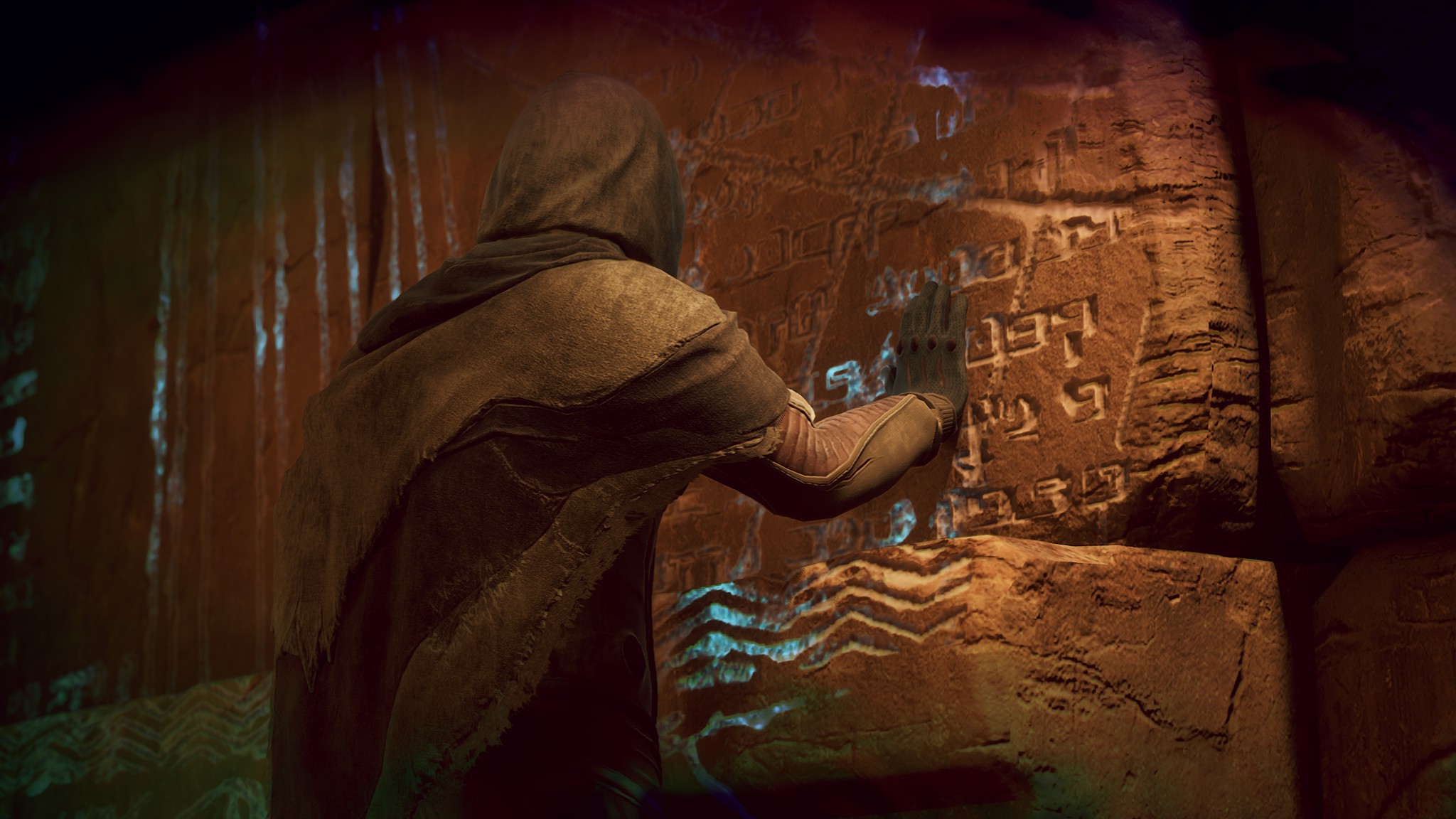 A hooded figure touching runes on a rock wall