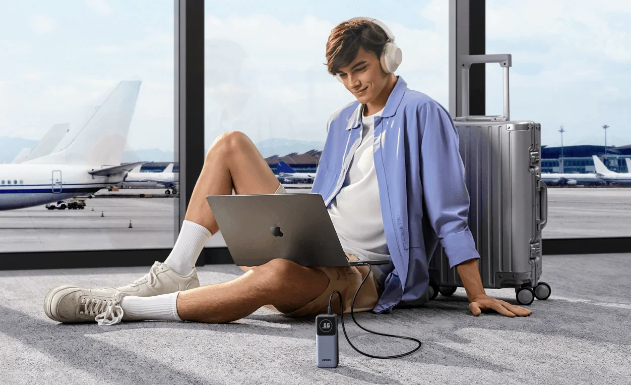 Ugreen power bank being used to charge a laptop at an airport
