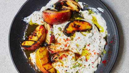A plate of grilled peaches on top of stracciatella 