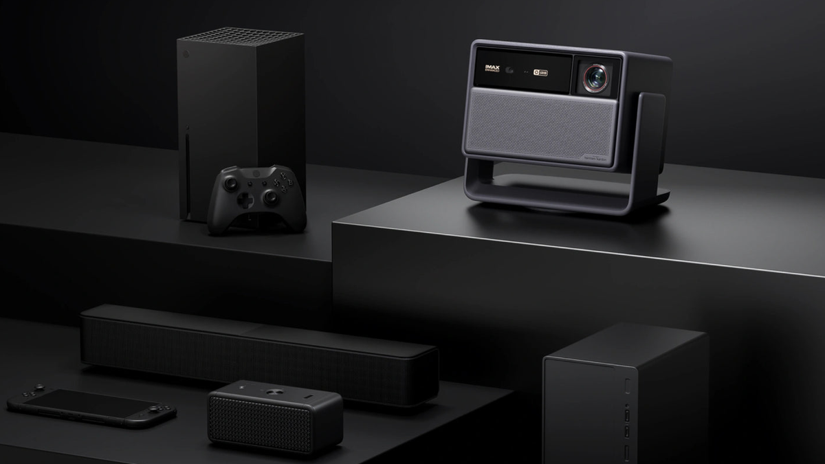 Xgimi Horizon 30 Series alongside various things you can connect: Xbox Series X, soundbar, bluetooth speakers. Theyre moodily lit on a multi-level black surface against a black background