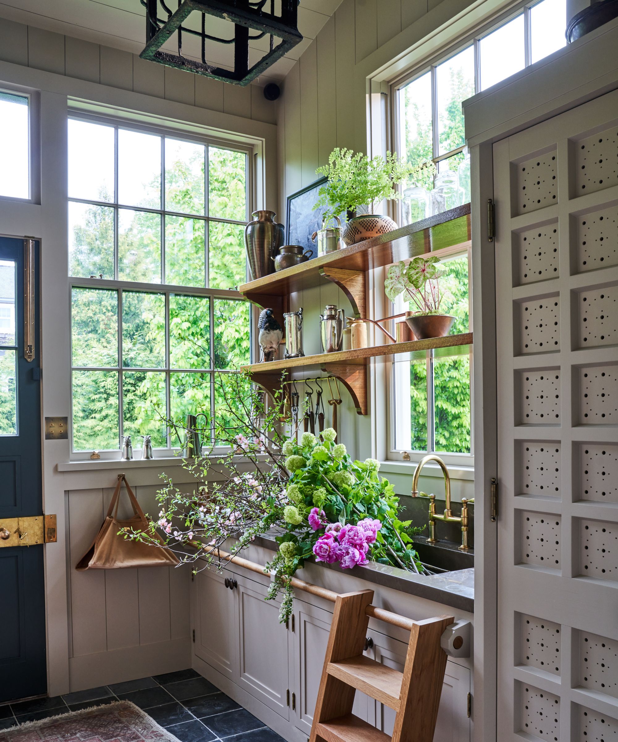 Bryan Graybill's cutting room with a wooden ladder, sink filled with flowers and shelf storage