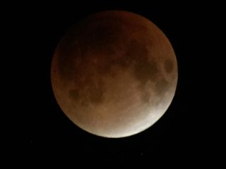 Veteran night sky photographers Imelda Joson and Edwin Aquirre used a spotting scope and smartphone to capture this view of the total lunar eclipse of Sept. 27, 2015 as seen from the Burlington area of Massachusetts.