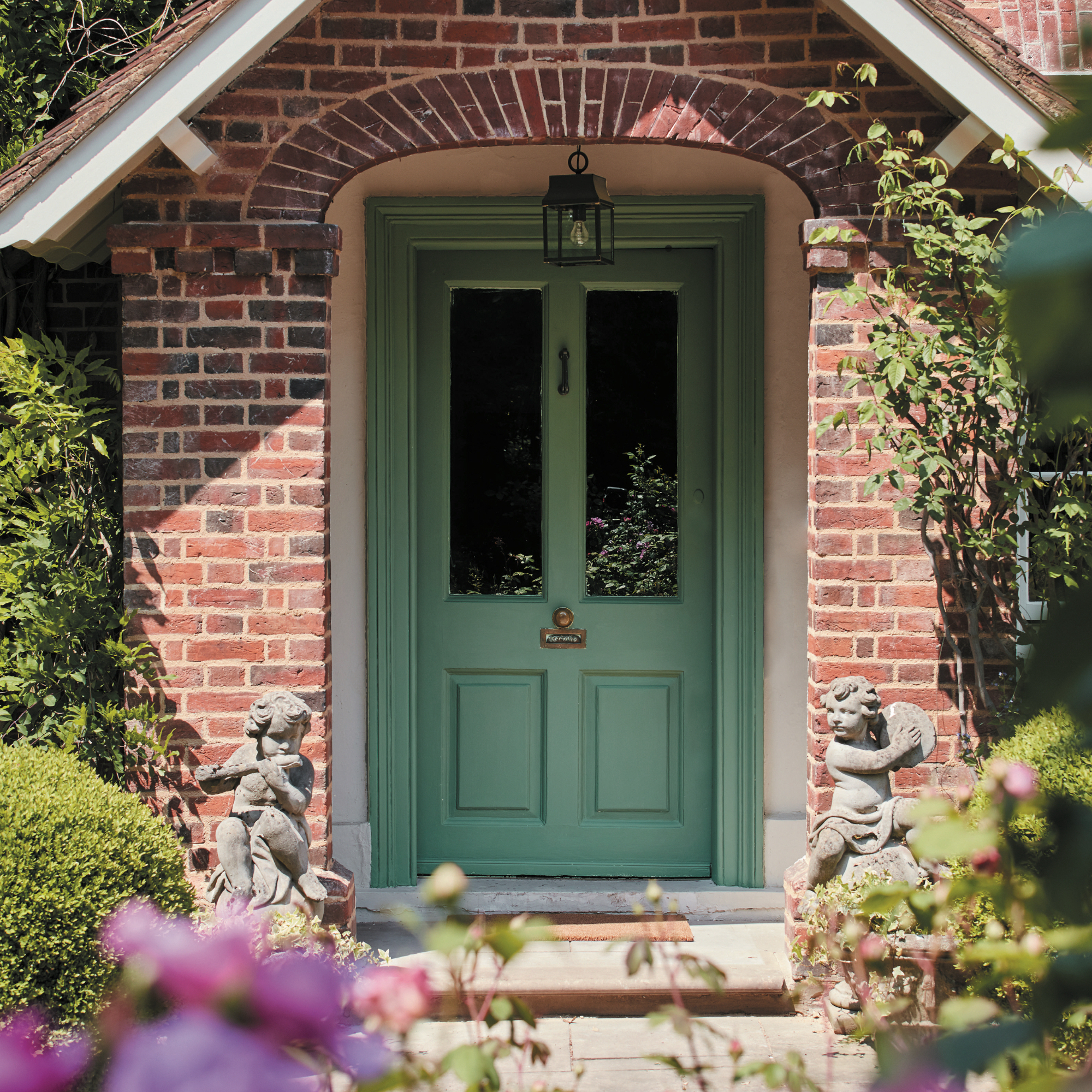 small front porch ideas, cottage porch with green painted front door and frame, plants and flowers