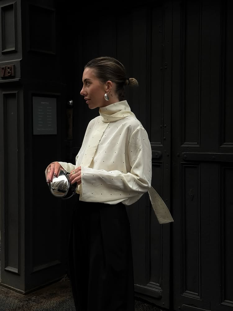 @hannahlewisstylist wears a polkadot scarf top with a silver orb clutch and earrings