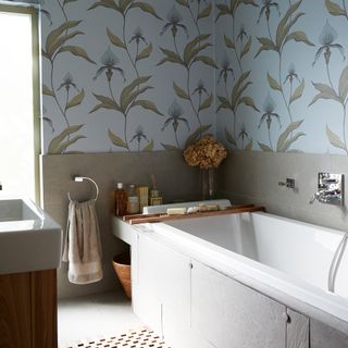 bathroom with flower leaves designed wallpaper and bathtub