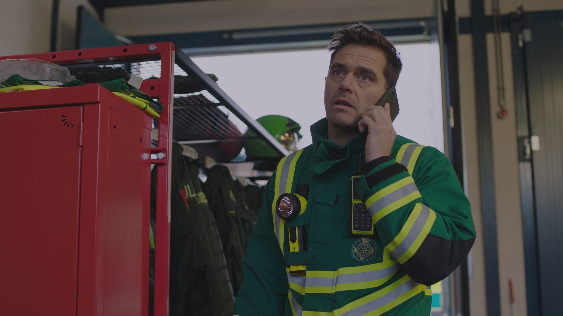 Iain Dean in high-viz clothing, looking concerned while taking a phone call.