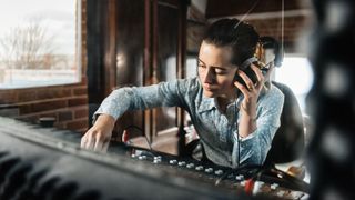 Woman listening to headphones in a recording studio