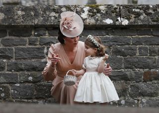 TOPSHOT - Britain's Catherine, Duchess of Cambridge (L) speaks to her daughter Britain's princess Charlotte, a bridesmaid, following the wedding of her sister Pippa Middleton to James Matthew