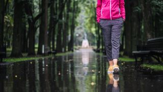 Carefree young woman enjoying relaxing walk after rain
