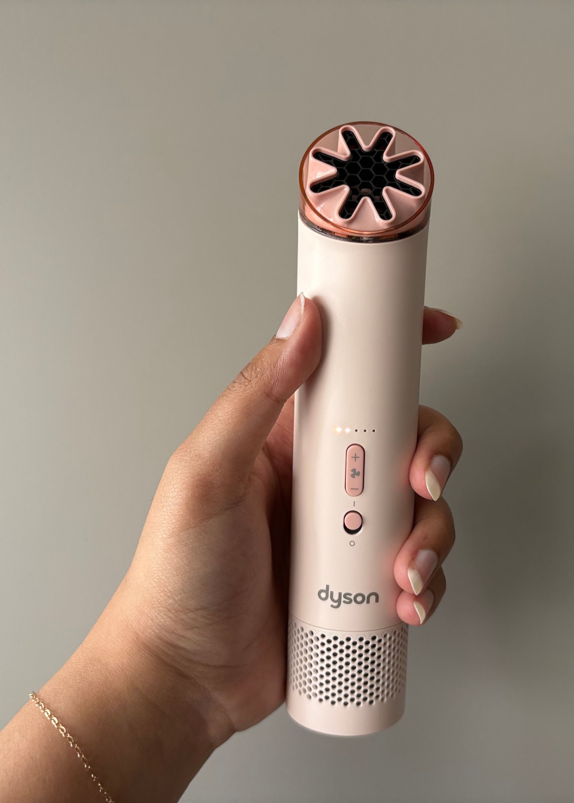 A hand holding the Dyson HushJet Mini Cool Fan