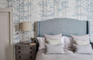 bedroom with bed and headboard and blue and white wallpaper
