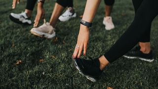 A photo of runners stretching wearing the best running shoes 