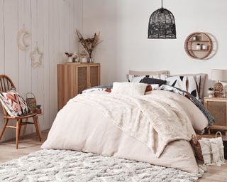 A cozy cream bohemian small bedroom with double bed and rattan furniture