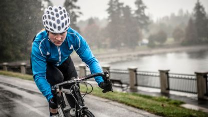Woman cycling in the rain