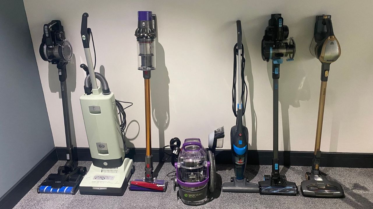 How we test vaccums at woman&amp;home - the SEBO, Hoover, Dyson, Beldray, and Bissel vacuums lined up on a wall