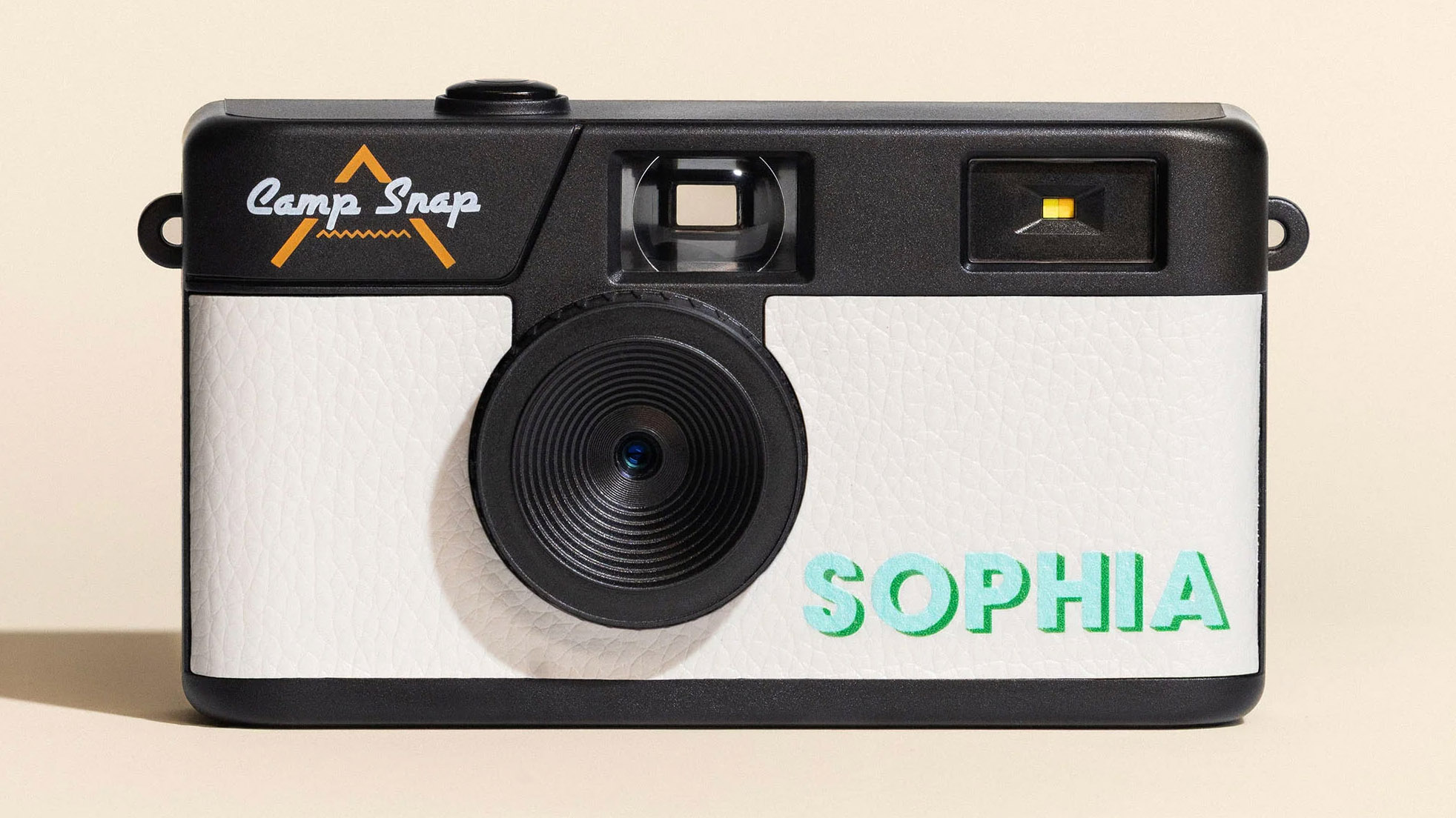 This is a picture of the arctic white Camp Snap Custom taken front-on with a beige background. The personalised text on the front reads 'Sophia' and is in the teal text font choice
