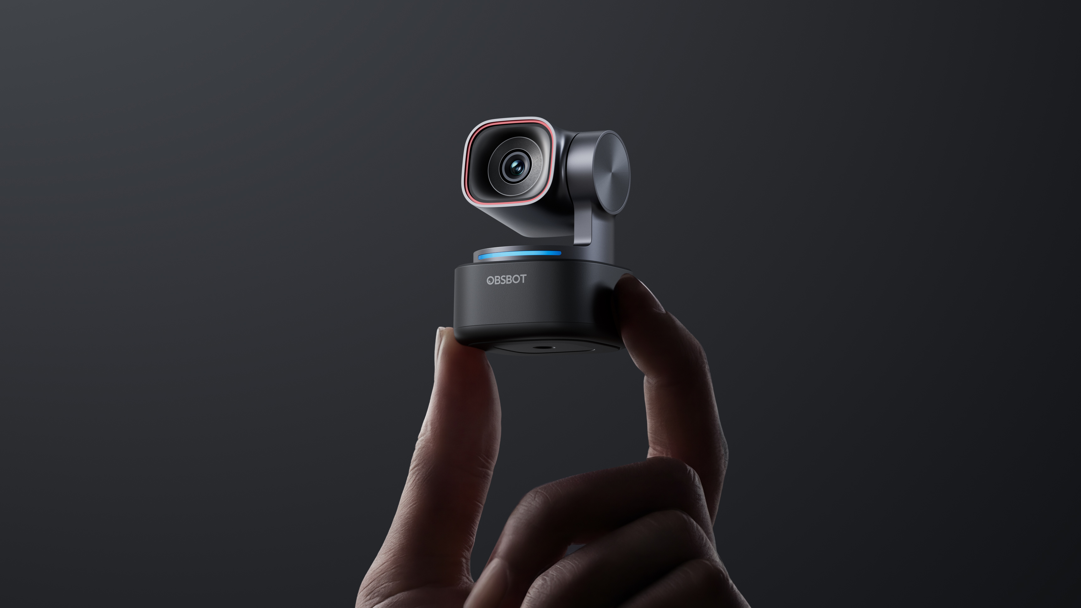 Obsbot Tiny 3 in hand on black background