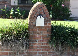 mailbox inset into a brick walls and planting