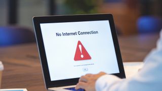 Person using laptop showing no internet connection