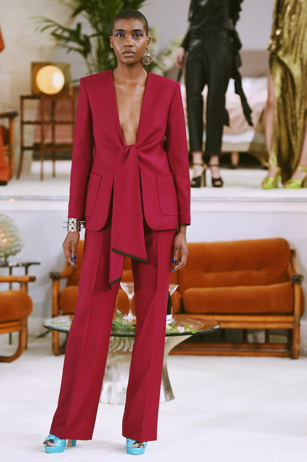 Model wearing bright tailored jacket, matching trousers and light blue open-toe sandals