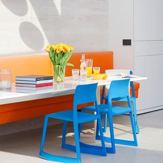 conservatory with orange seating bench and blue chairs