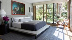 Bedroom with large glass doors overlooking trees