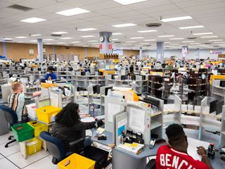 IRS employees work at various tingle tables used in the extraction process for sorting taxpayers returns into various cubby holes at the Internal Revenue Service in Austin, Tx. (Credit: Matthew Busch for The Washington Post via Getty Images)