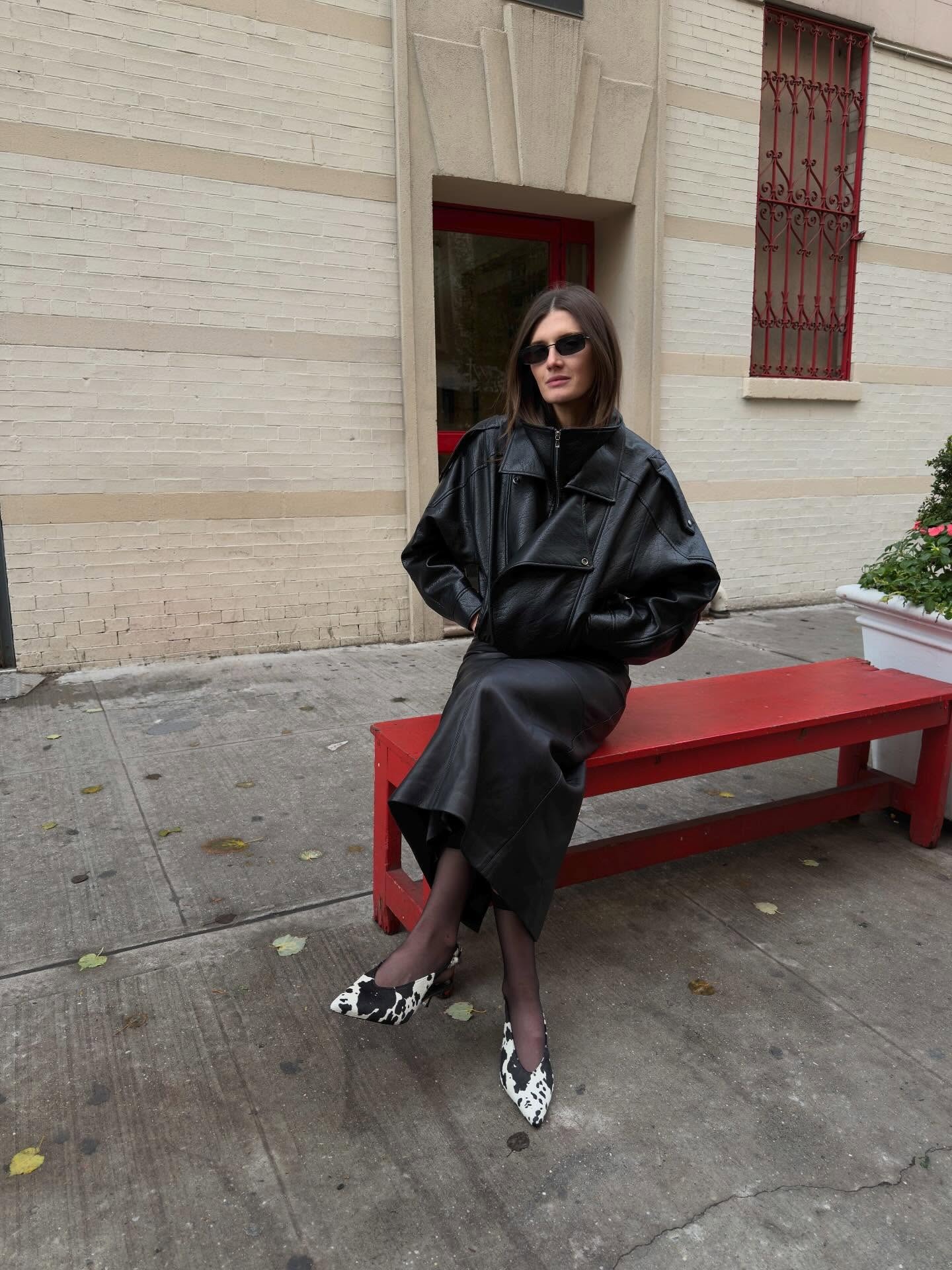 @cocoschiffer wears a pair of Dolce Vita cow-print calf-hair heels, with sheer tights, a slip skirt, and oversized funnel-neck leather jacket.