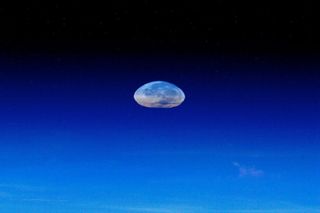 The Supermoon appears to be sinking into the atmosphere. The image was taken by André Kuipers from aboard the ISS on May 5, 2012.