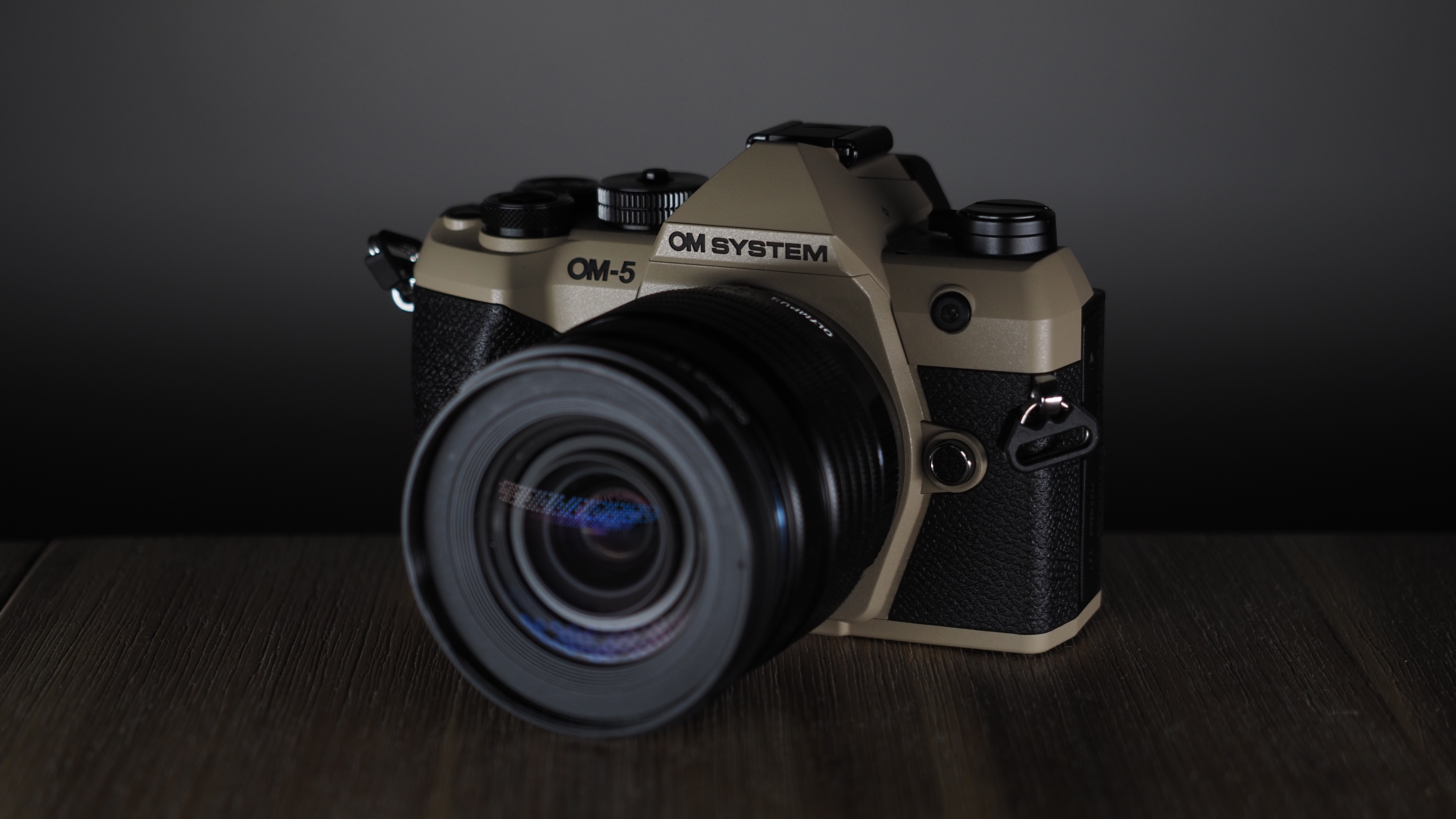 OM System OM-5 Mark II on a wooden surface with an Olympus M.Zuiko 12-45mm lens