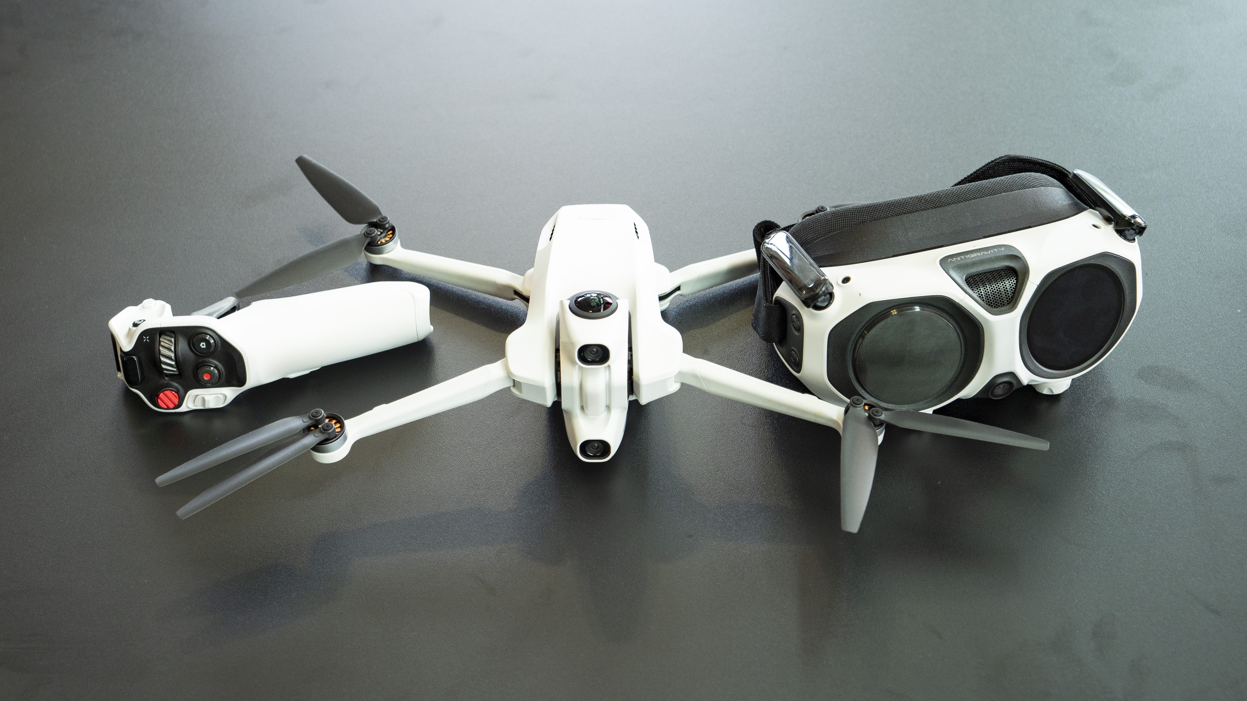 Antigravity A1 drone by Insta360 alongside its headset and controller, on a black table