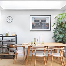 Wooden dining table with curved back dining chairs in dining area beneath rooflight