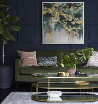 Blue living room with green sofa and wall art