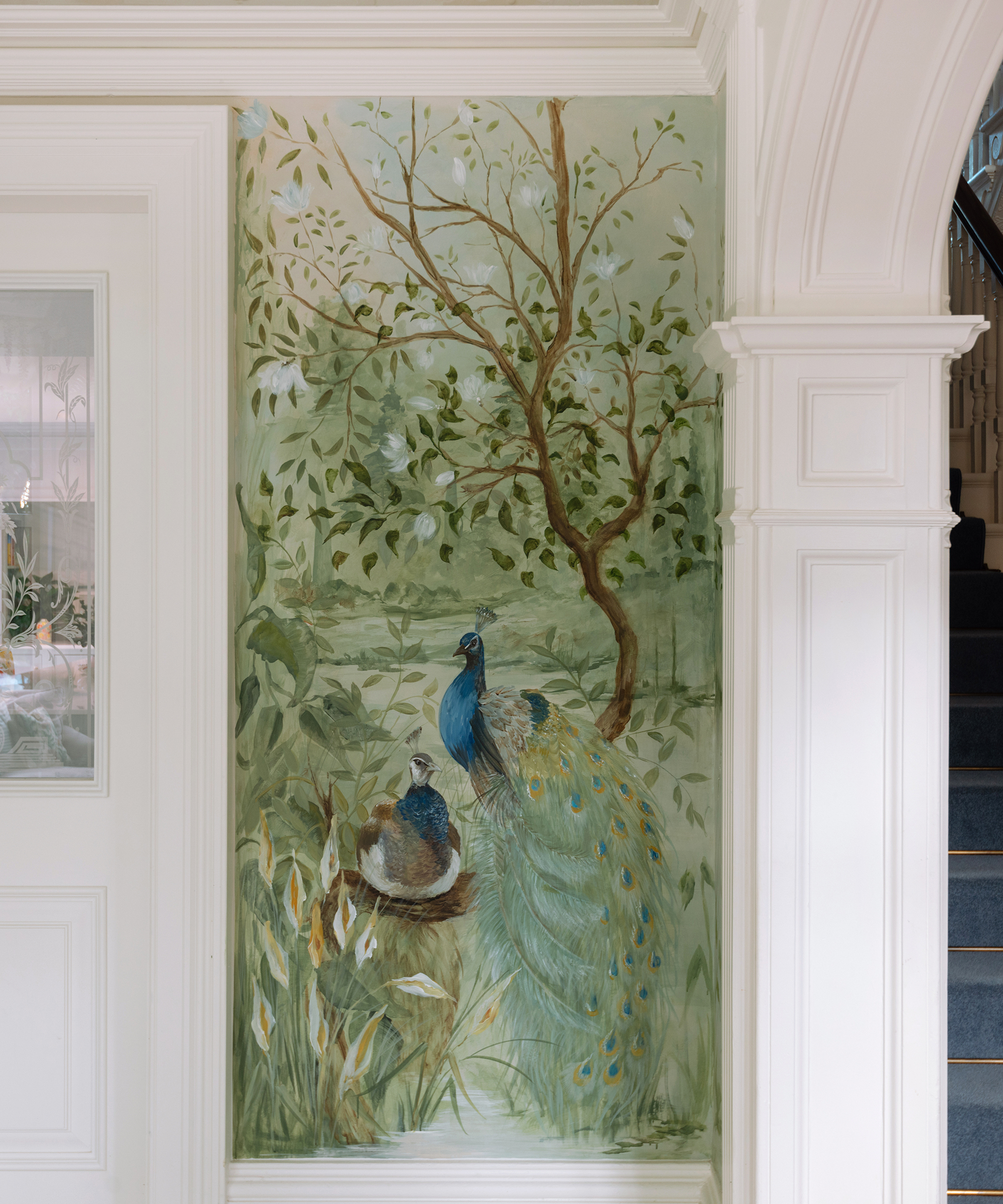 intricate handpainted wall mural with trees, peacocks and other birds