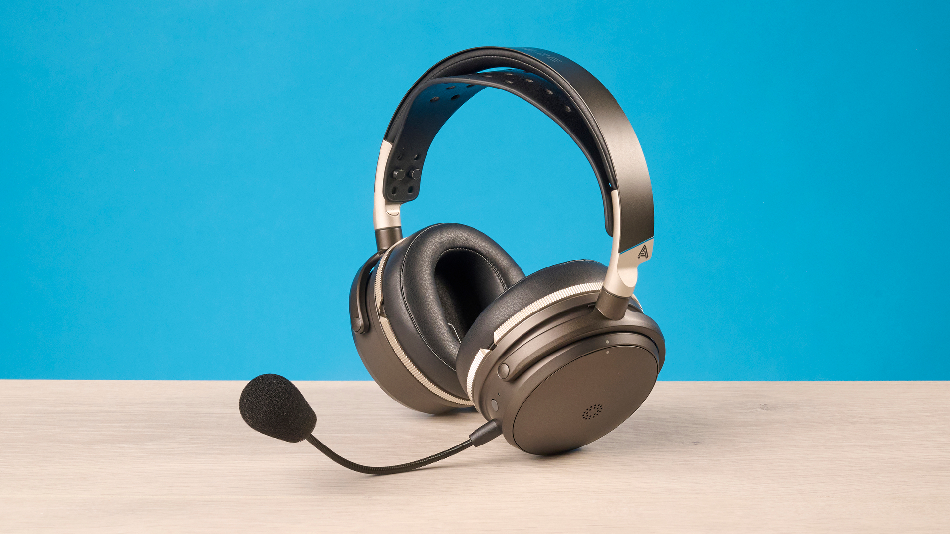 The Audeze Maxwell 2 ANC on a wooden desk with a blue background