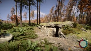 Sons of the Forest food bunker - a narrow cave entrance is set into rock near tall, autumnal trees