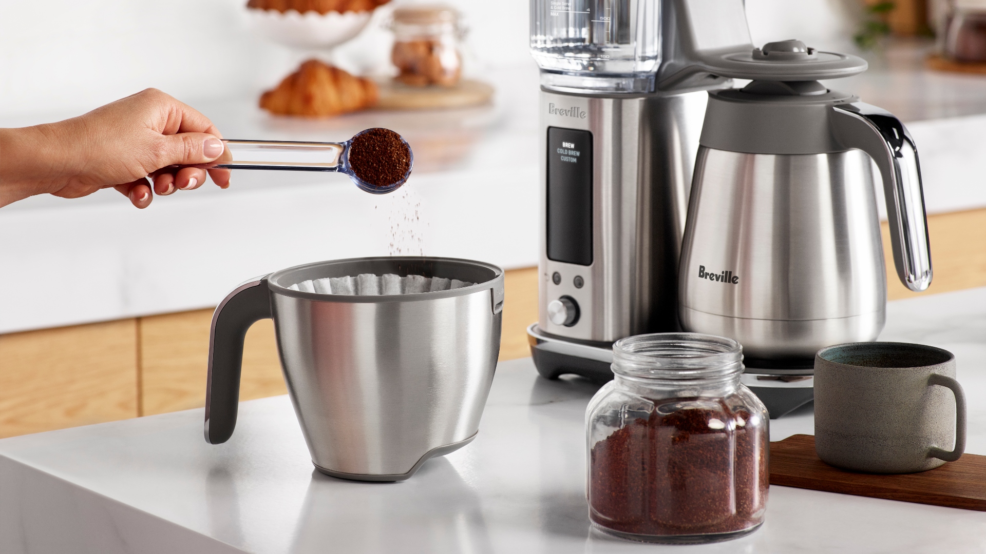 Pouring coffee grounds into the Breville Luxe Brewer