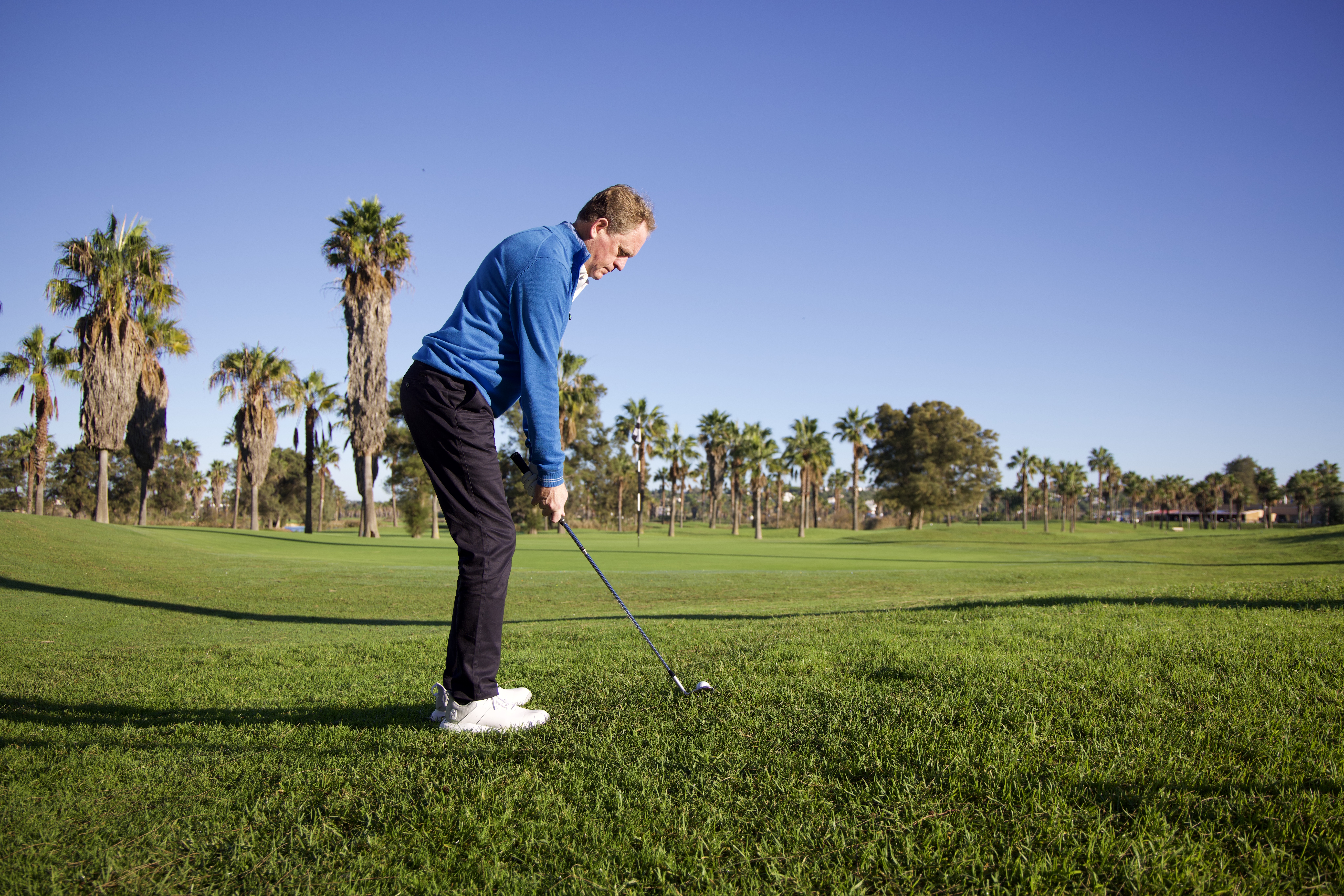 Keith Wood hitting a chip shot from an uphill lie around the green